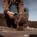 Man pulling on Rebel™ Durango western boots on the back of a pickup truck