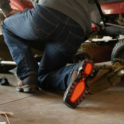 Man working on mower wearing Maverick XP™ Durango work boots 