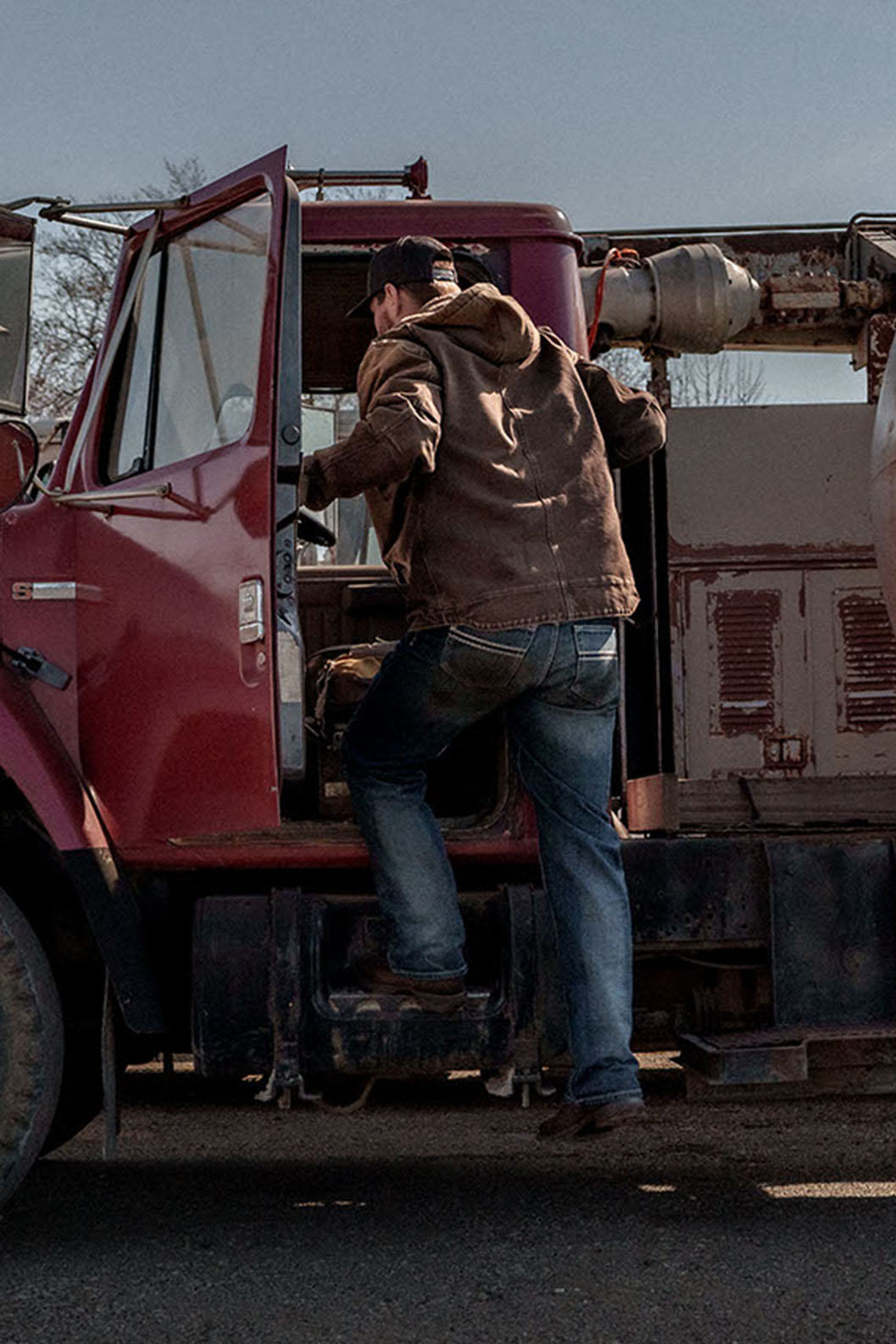 Woman leaning against wall wearing tall red cowgirl boots